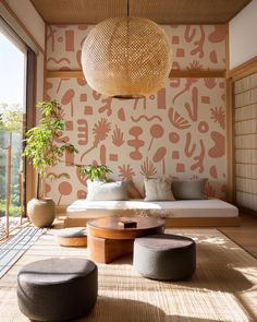 a living room filled with lots of furniture next to a wall covered in plants and animals