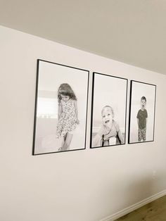 three black and white photos hang on the wall in an empty room with wood flooring