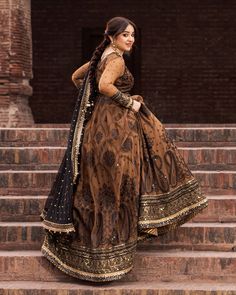 a woman in a long dress standing on some steps