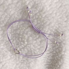 Purple string bracelet with silver heart charm.    Wear as a reminder of BTS coming back to us in 2025. Made of Korean waxed thread.   Finished with clear somewhat iridescent glass beaded  ends.  Lead nickel and cadmium free zinc alloy metal heart charm.  This bracelet fits wrists up to 9 inches around.  The length is adjustable with a sliding knot.  Pull both beaded ends to shorten length, and to lengthen pull knot away from wrist. AFBF!  Borahae! Cheap Purple Bracelets For Friendship, Cheap Adjustable Friendship Bracelets With Heart Charm, Cheap Purple Casual Friendship Bracelets, Cheap Casual Purple Friendship Bracelets, Affordable Casual Purple Friendship Bracelets, Cheap Purple Friendship Bracelets For Festivals, Purple Beaded Bracelets, Purple Line, Infinity Charm