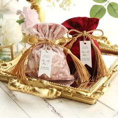 two bags of soap sitting on top of a gold tray next to flowers and other decorations