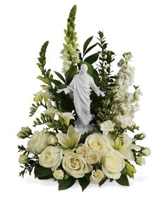 a bouquet of white flowers and greenery with a statue in the center on a white background