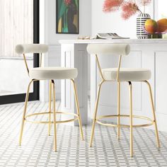 two white bar stools sitting in front of a counter top with flowers on it