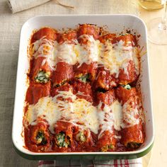 a casserole dish with meat, cheese and spinach in it on a table