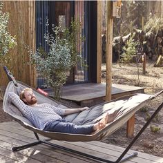 a man laying in a hammock on a deck