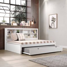 a white bed with drawers underneath it in a room