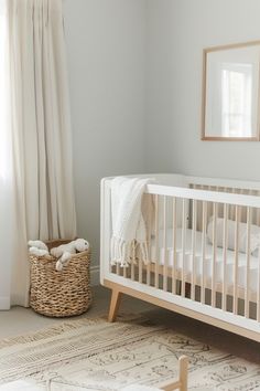 a baby's room with a white crib and neutral decor