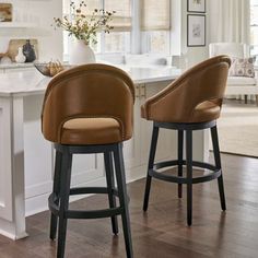 two brown bar stools sitting in front of a kitchen island