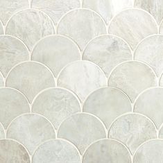 a close up view of a white marble mosaic tile flooring pattern with wavy, scallop - like shapes