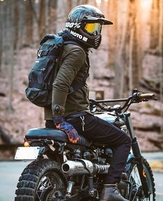 a man sitting on top of a motorcycle wearing a helmet