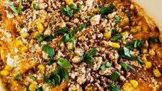 a casserole dish with corn, cheese and herbs on top is ready to be eaten