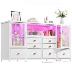 a white cabinet with pink lighting in the front and drawers on both sides is shown