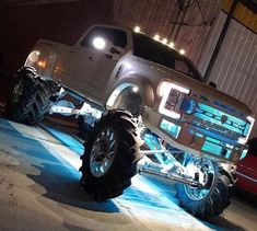 a large truck with big tires parked in a garage