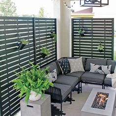 an outdoor living area with couches, chairs and fire pit in the middle of it