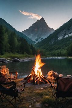 two chairs sitting around a campfire with mountains in the background