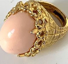 Pauline Rader Pink Cocktail Ring, Angel Skin Cabochon and Elegant Modernist Brutalist Golden Setting size 8 Awesome rare vintage glamour jewelry Art Deco revival statement ring 1970s or 80s In excellent collected vintage condition Arrives polished & gifted nicely 🎀 www.MySoulRepair.com an Etsy shoppe 🌿 www.MySoulRepair.NYC glamour jewelry & gifts Curated by marta michaud 🌸 Pink Cocktail Ring, Glamour Jewelry, Pink Cocktails, Personalized Gift Tags, Vintage Glamour, Art Deco Jewelry, Gold Style, Cocktail Rings, Faux Pearl