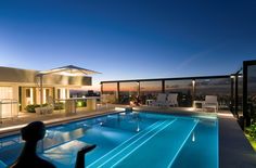 an outdoor swimming pool at night with the lights on