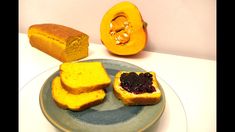 two pieces of bread on a plate next to an orange and some other food items