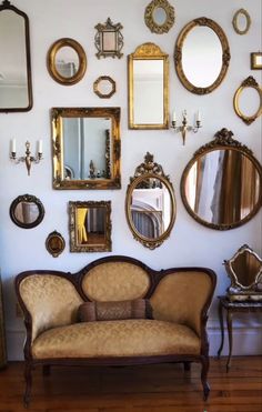 a living room filled with lots of mirrors on the wall next to a couch and chair