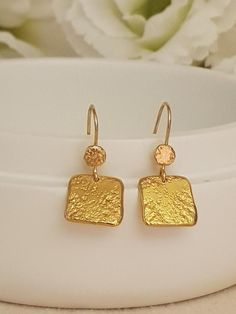 18K Gold  handmade hammered square earrings dangling from 18K solid Gold.Lightweight and comfy to wear these earrings are great sparkle for everyday!• They will make a great gift! • The total length of the earrings is 33 mm/ 1.4" approx from top to bottom. • Weight:4 Grams• Material: 18k Gold •  18k solid gold thick• Pendants Highet 34mm, Width 13mm. * Ear wires are gold  • All earrings with French ear wires come with silicon backings for extra protection. SKU EG055Have questions? Send me a conv Gold Nugget Earrings As Gift, Gold Square Earrings For Anniversary, Dainty Hand Forged Gold Earrings, Gold Hammered Rectangular Earrings, Textured Gold Earrings, Thick Gold Ring, Gifts For Anniversary, Unique Gifts For Sister, Earrings Dangling