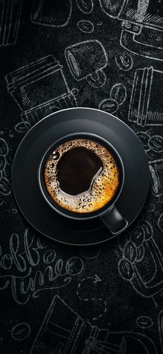 an espresso in a black plate on a chalkboard background with writing around it