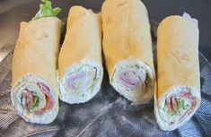 three sandwiches cut in half sitting on top of a glass plate