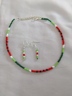 a necklace and earring set with beads on a white sheeted tablecloth,