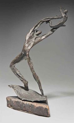 a bronze statue of a man on a rock with his arms outstretched and legs bent