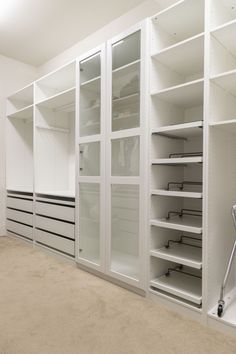 an empty walk - in closet with white shelving