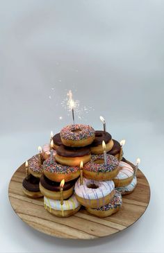 a wooden plate topped with donuts covered in frosting and sprinkles