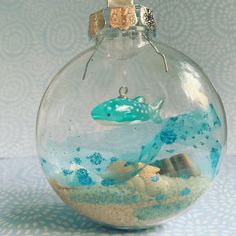 a glass ornament filled with sand and sea animals on top of a table