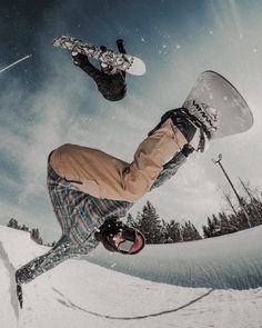 a snowboarder is doing a trick in the air