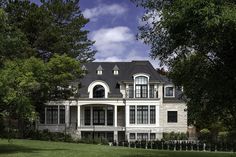 a large white house sitting on top of a lush green field