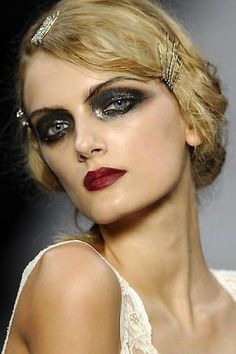 a woman with dark makeup and black eyeliners on the catwalk at a fashion show