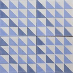 a blue and white tiled wall with triangular shapes on it's sides, including one in the center