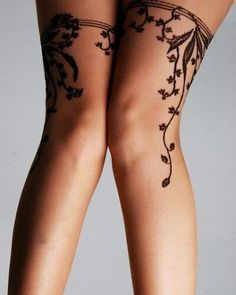 the legs of a woman with tattoos on her body and stockings over their ankles are shown