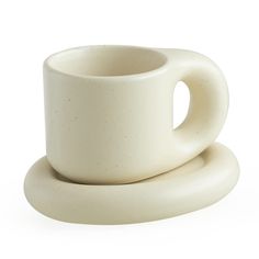 two white cups and saucers sitting side by side on top of each other in front of a white background