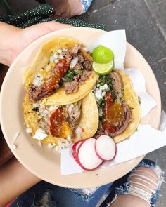 two tacos with meat and vegetables on a plate