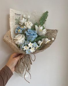 someone is holding a bouquet of flowers in their hand and it looks like they are made out of fabric