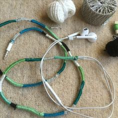 several cords and earphones on the floor next to yarn