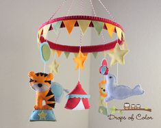 a crib mobile with stuffed animals hanging from it's sides and stars on the ceiling