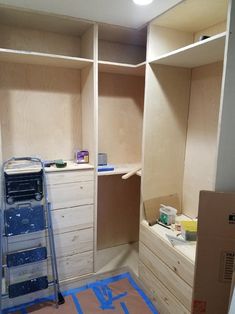 an unfinished closet is being built with plywood and paint on the floor next to it