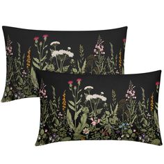 two black pillows with flowers and plants printed on the front, one is green and the other is pink