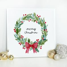 a christmas card with a red bow and holly wreath on it next to other holiday decorations