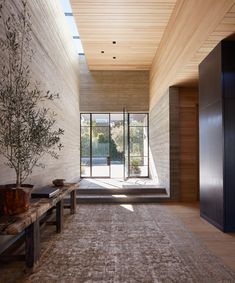 a living room with a large area rug on the floor next to a wooden bench