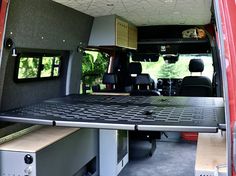 the back end of a van with its cargo door open and shelves in place to hold items