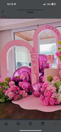 a pink display with flowers and balloons on it