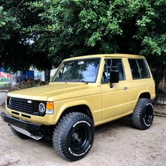 a yellow suv parked in front of some trees