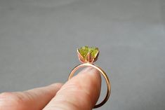 Rough Peridot ring in my best selling lotus flower design. A handcrafted rose gold fill band and cup filled with small rough Peridot gemstones, my signature design. Created to represent a delicate lotus flower. Organic, natural Peridot greens in varying shades look pretty and unique next to the rose gold color. Peridot is August's birthstone and Libra signs. Made to order. Scroll down to read more... I love this ring as an ultra unique, any occasion ring for her! For special gift giving occasion Elegant Peridot Crystal Ring As A Gift, Peridot Birthstone Ring In Gold For Gift, Elegant Peridot Gemstone Gift, Nature-inspired Peridot Rings As Gift, Green Peridot Birthstone Ring, Dainty Style, Lotus Flower Jewelry, August Birthstone Ring, Lotus Flower Design, Lotus Design