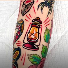 a tattoo with an image of a lantern and other things on it's arm